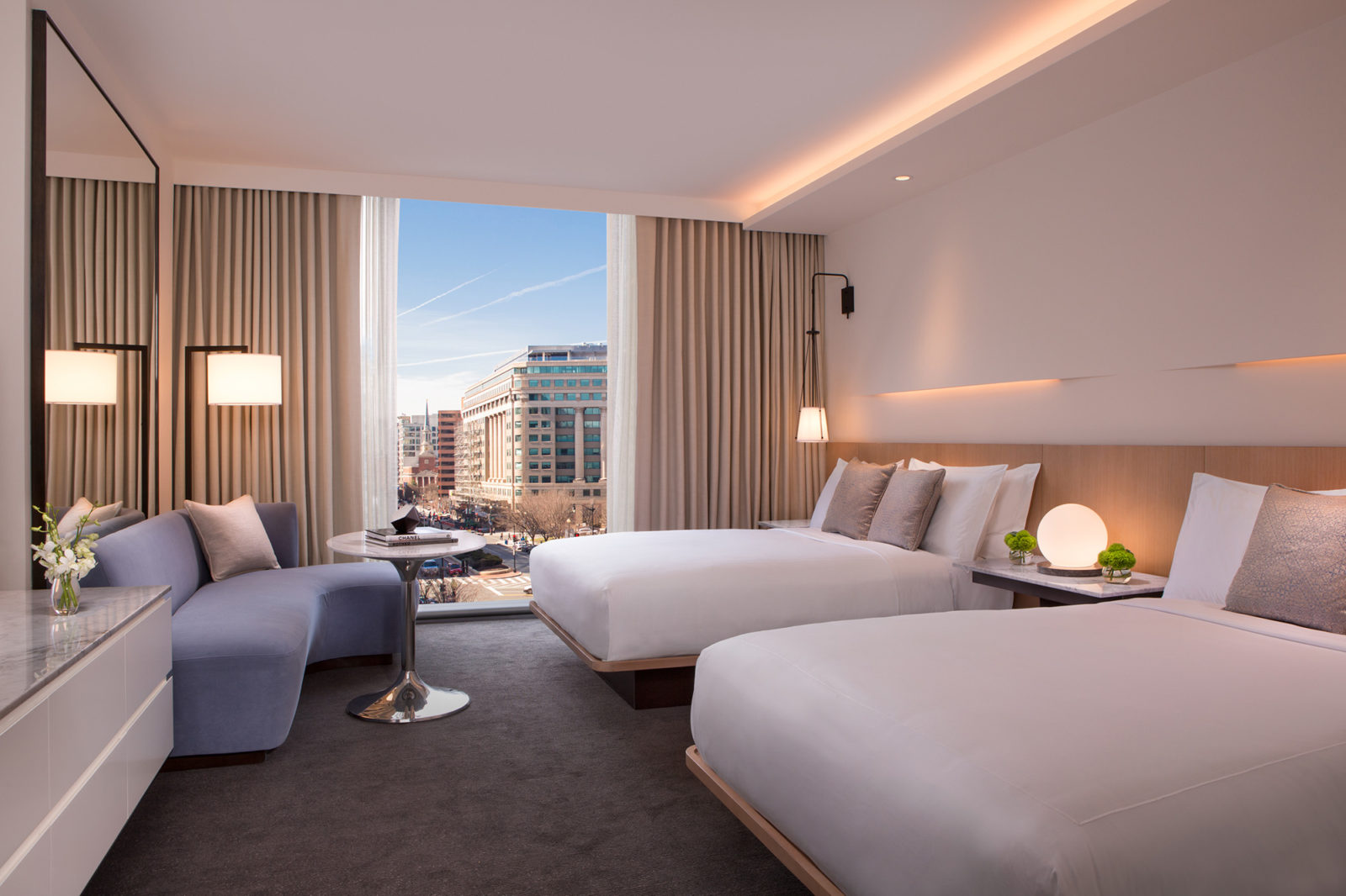 Two queen beds and room showing large window with view of DC sky